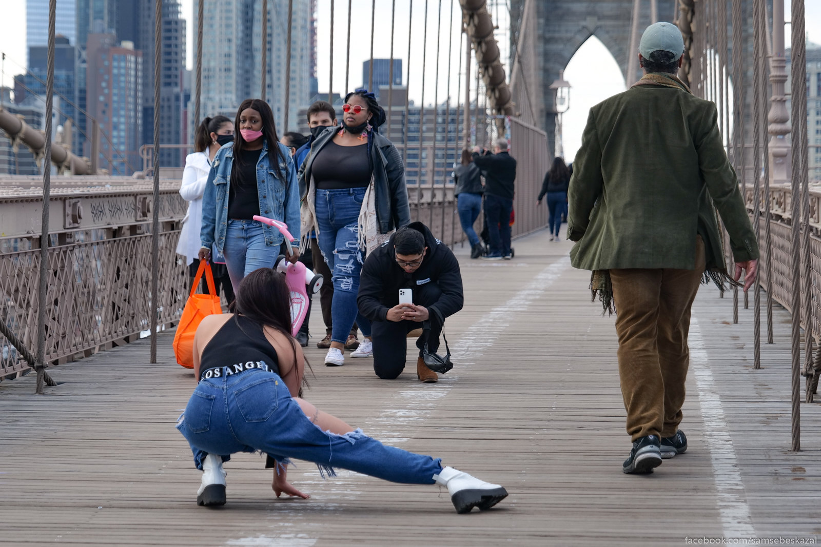 A photo of someone taking a photo of someone on the Brooklyn Bridge