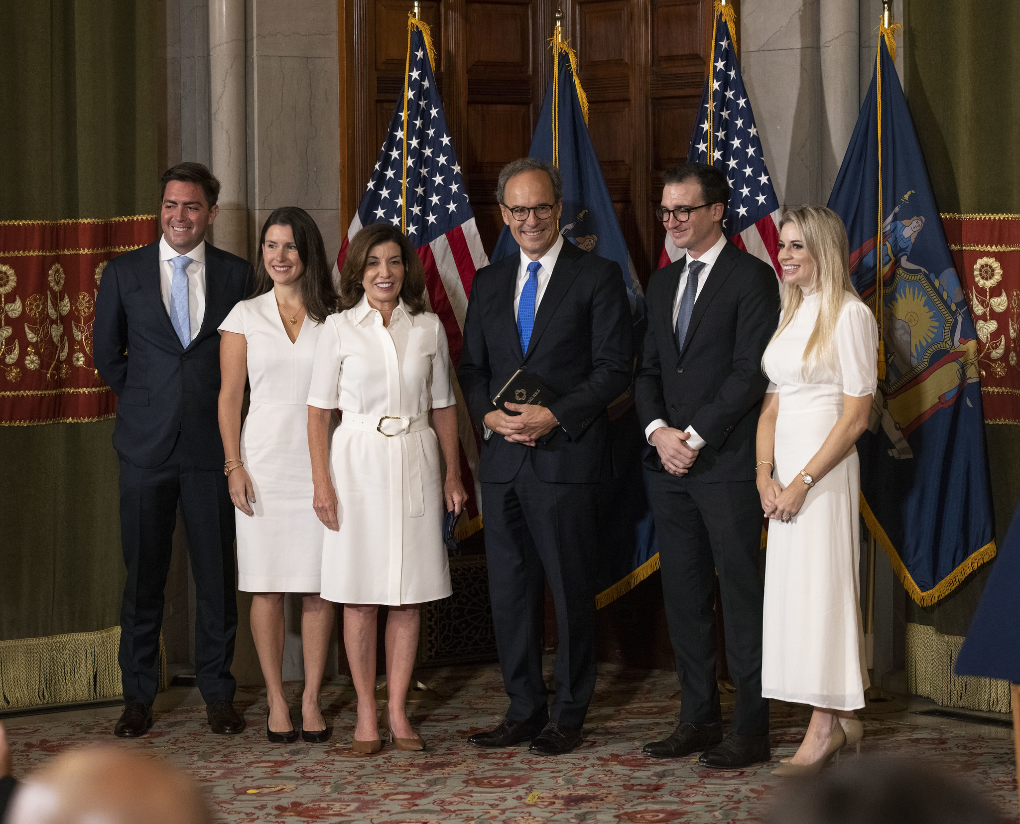 Governor Hochul in a white dress with her family—her daughter and daughter-in-law are wearing white dresses too
