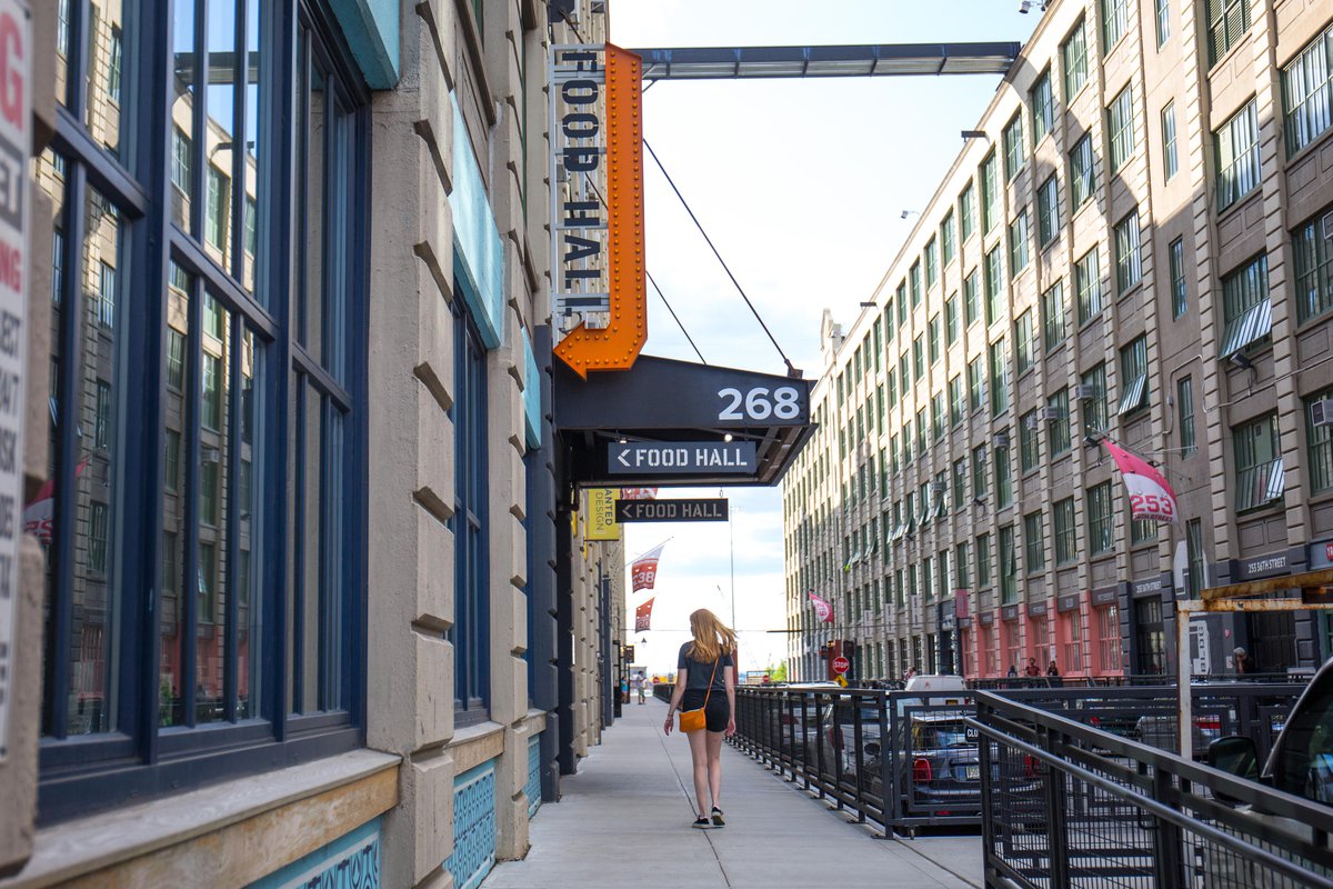 A woman walks outside of a food hall in Industry City in Sunset Park in 2019.