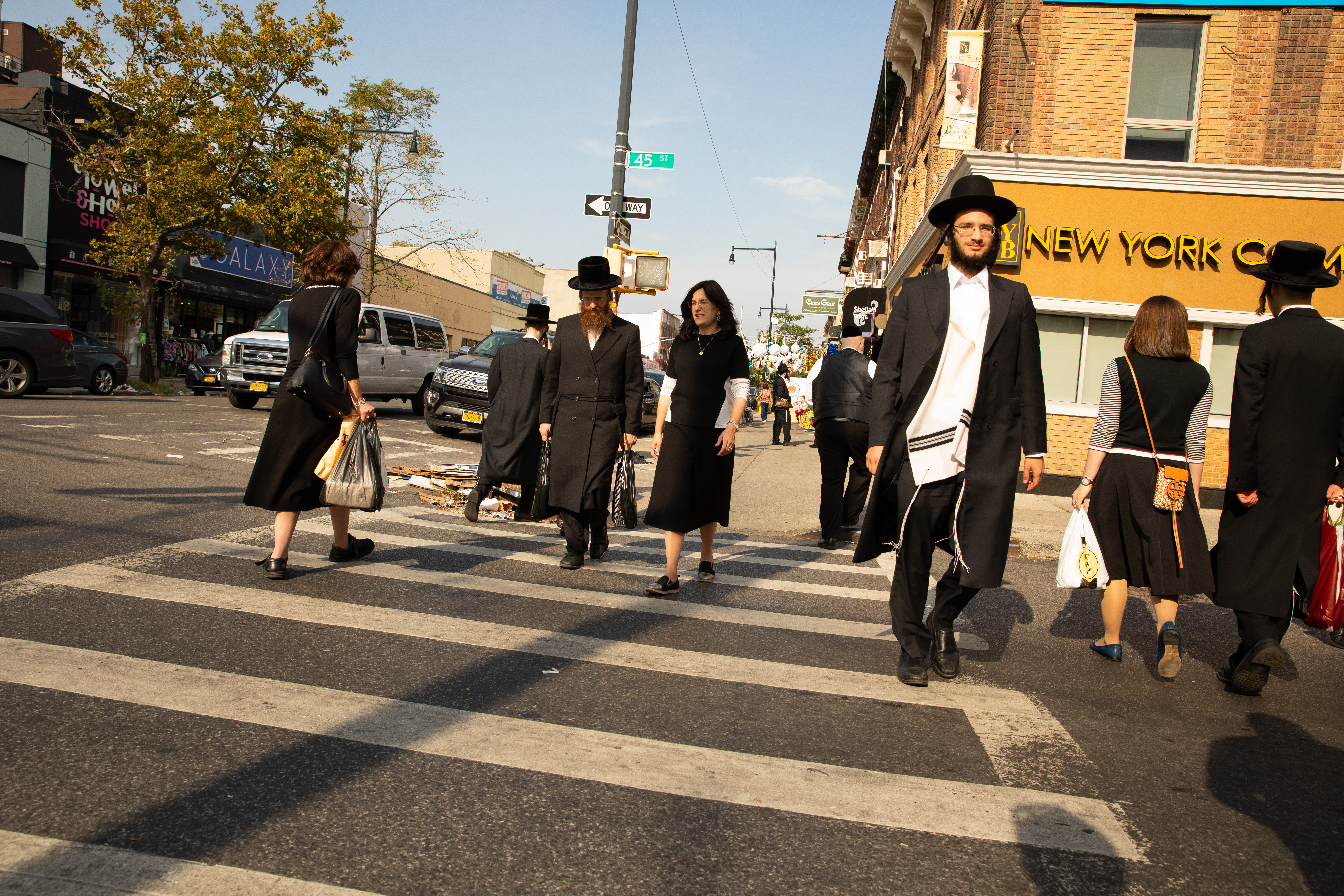 Hasidic New Yorkers without masks cross the street in Borough Park