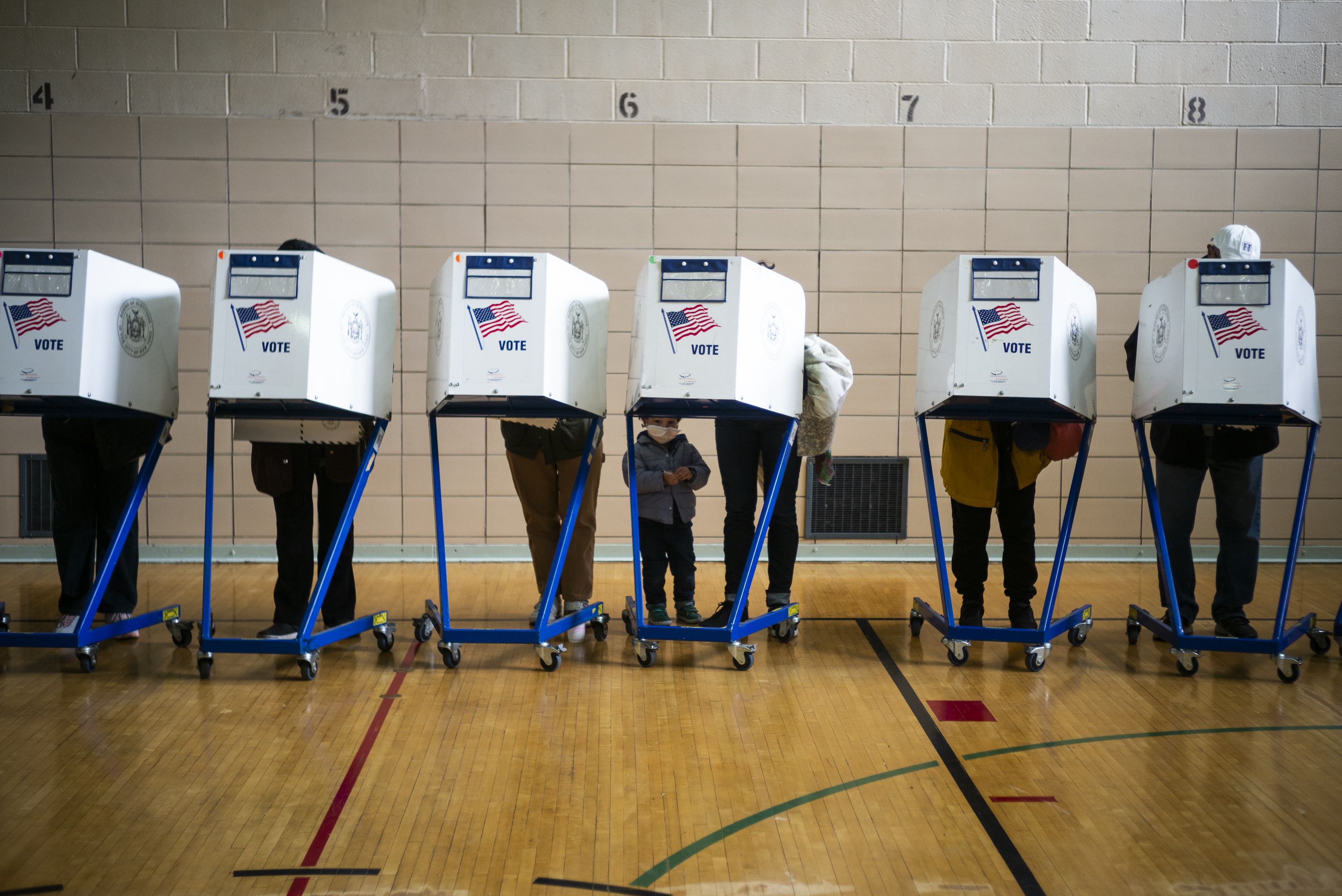 A row of voters inside a gymnasium.
