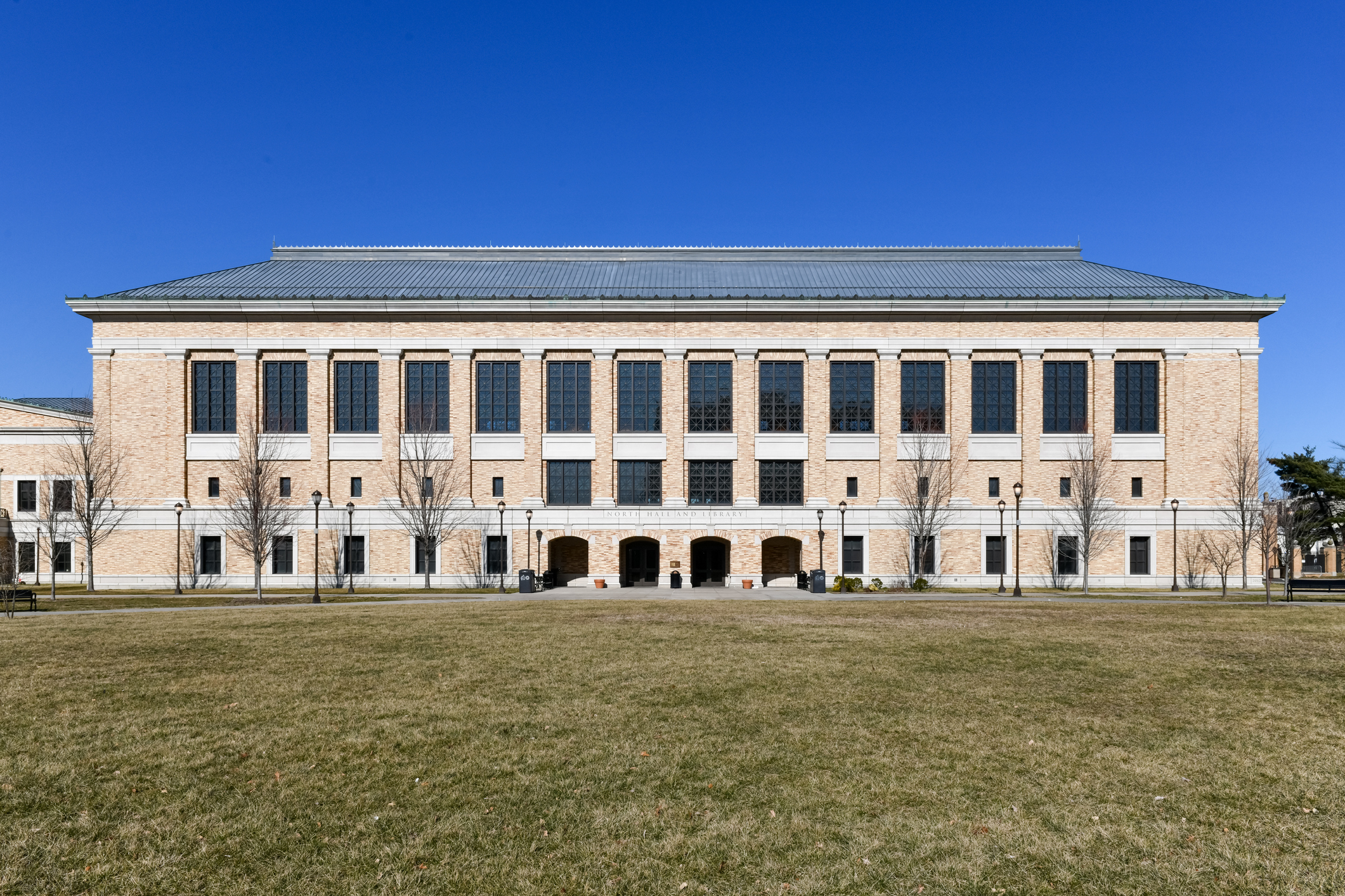 A photograph of a library with a lawn in front