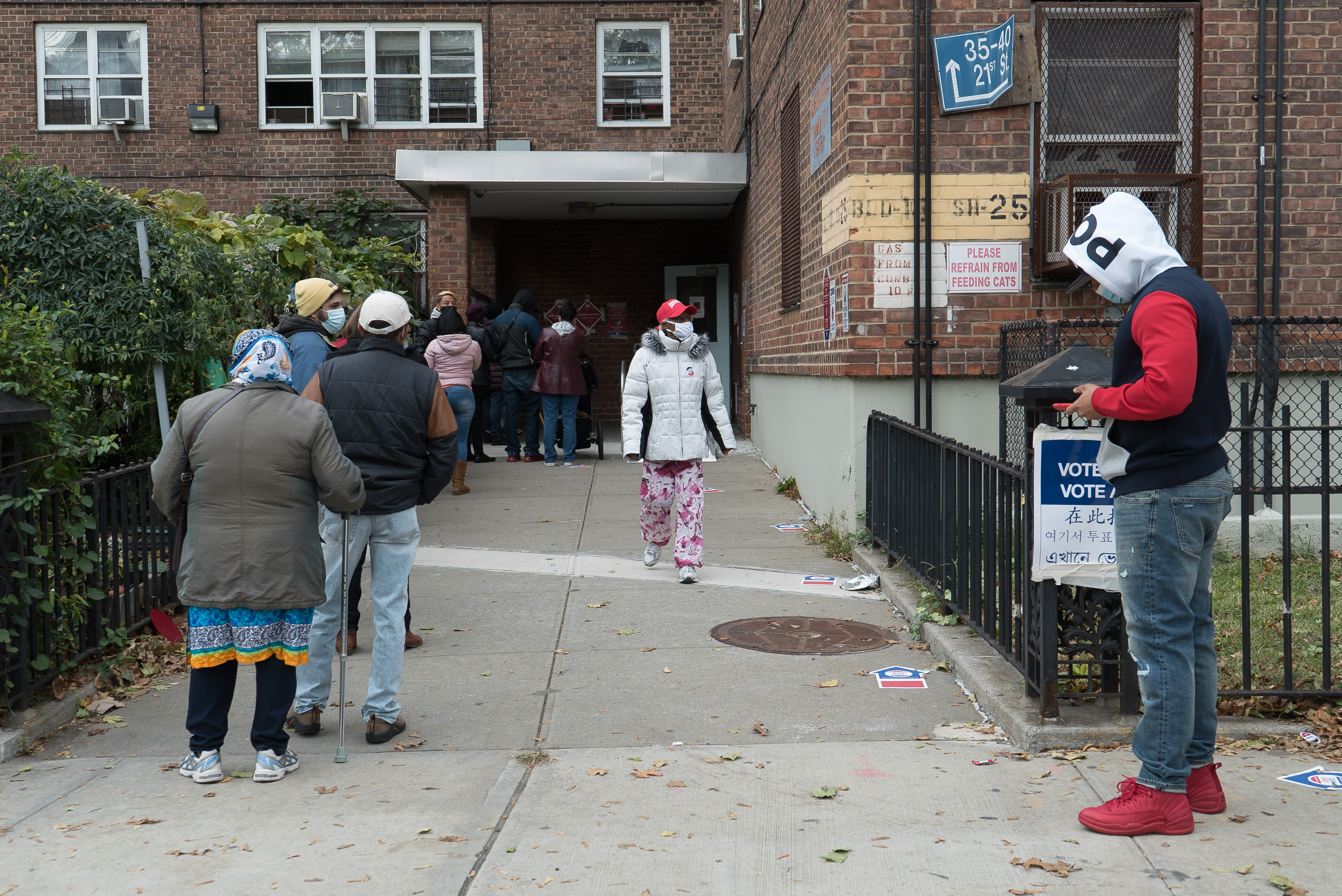 Dozens of people line up outside of a polling station in Queens.