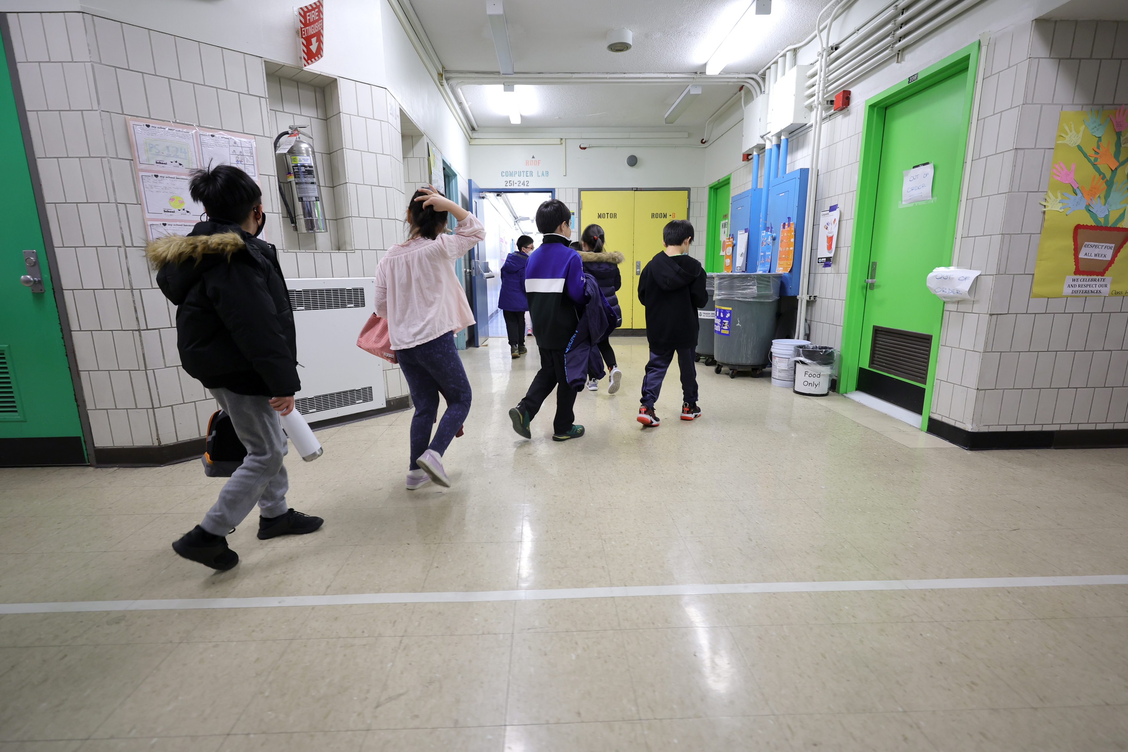 Students walking in a New York City classroom.
