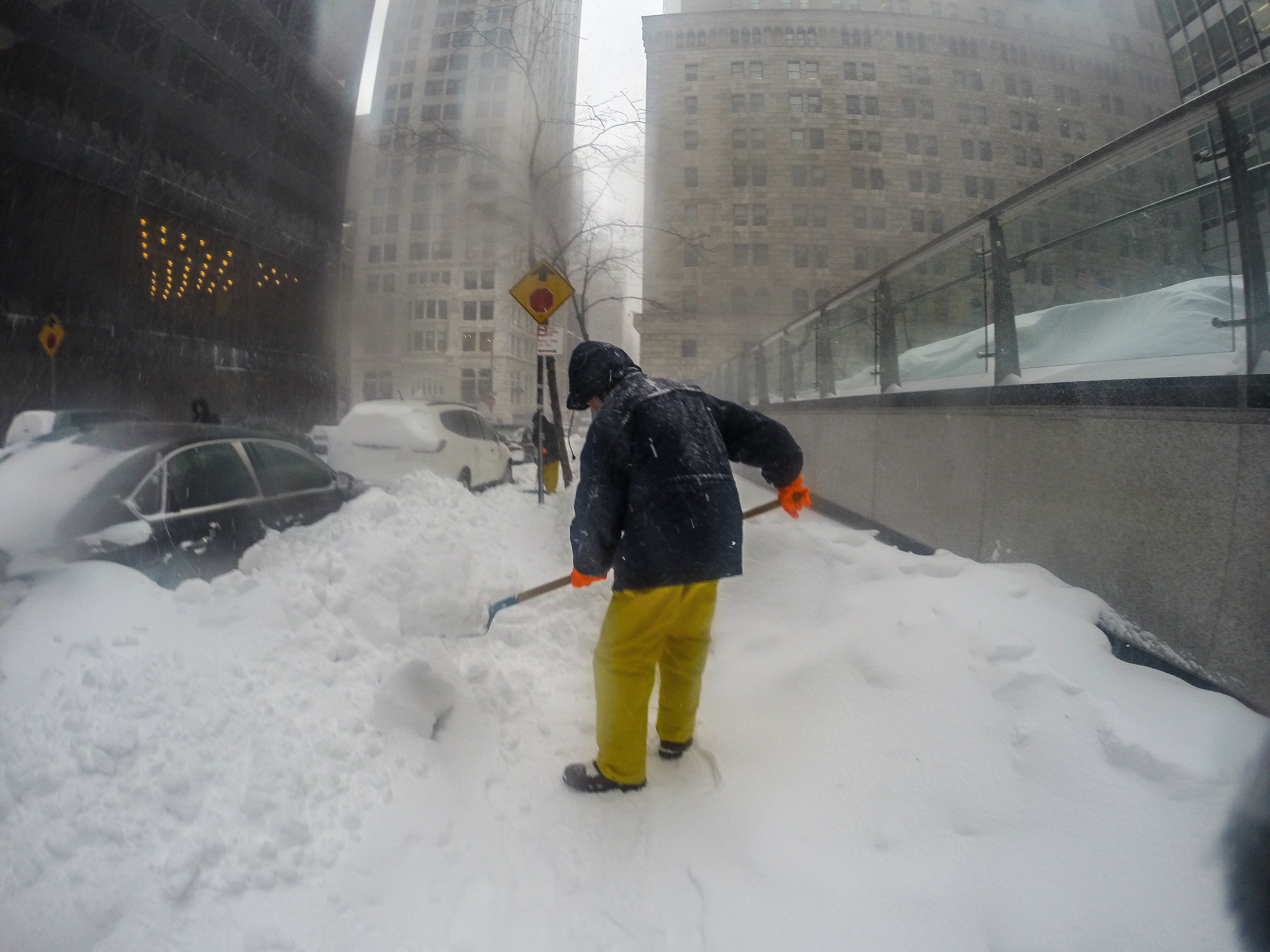 A person shovels snow from a New York City sidewalk following a blizzard.