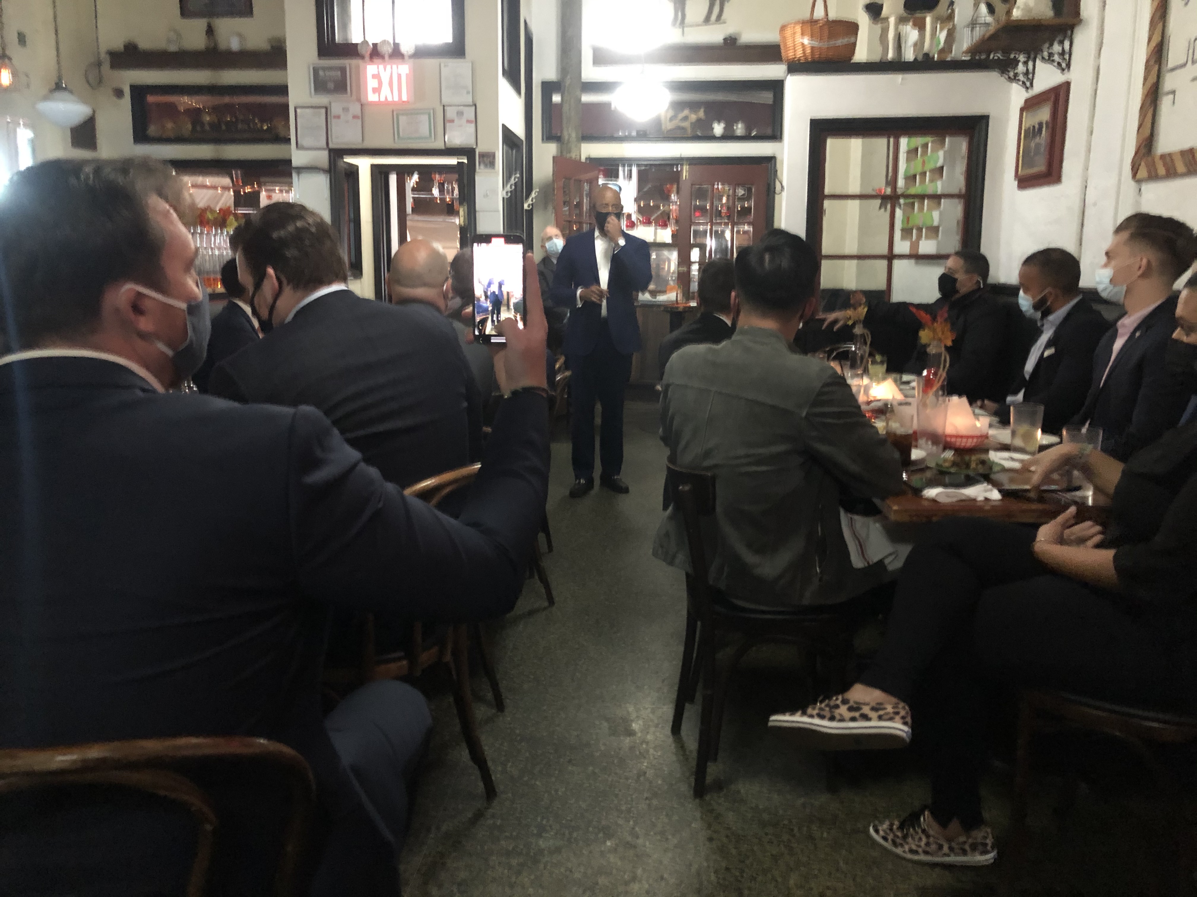 Brooklyn Borough President Eric Adams stands at the back of a dimly lit restaurant in the Upper West Side speaking to attendees seated at tables at a fundraiser he hosted.