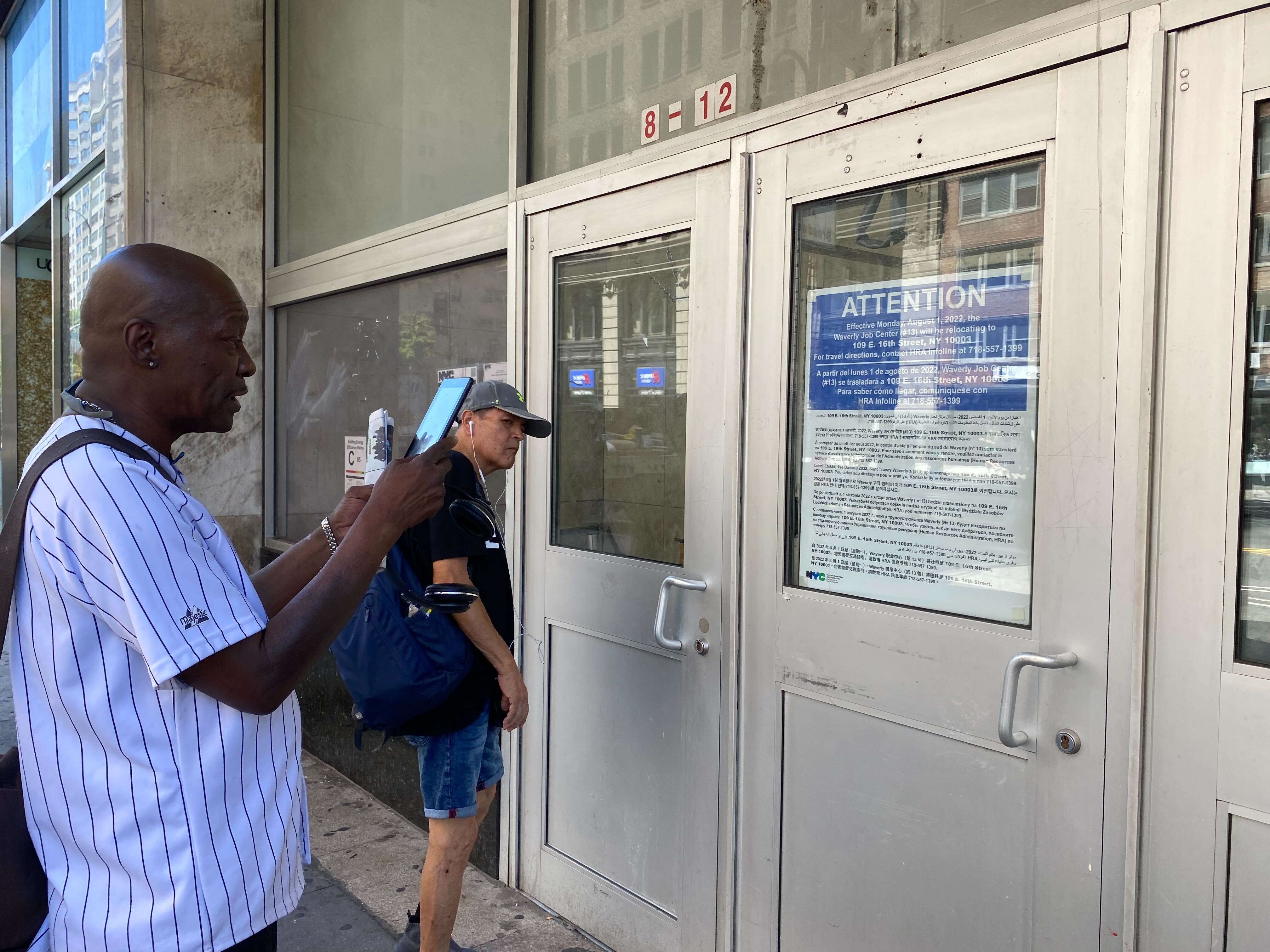 A photo of people reading the closure notice at a Union Square benefits center.