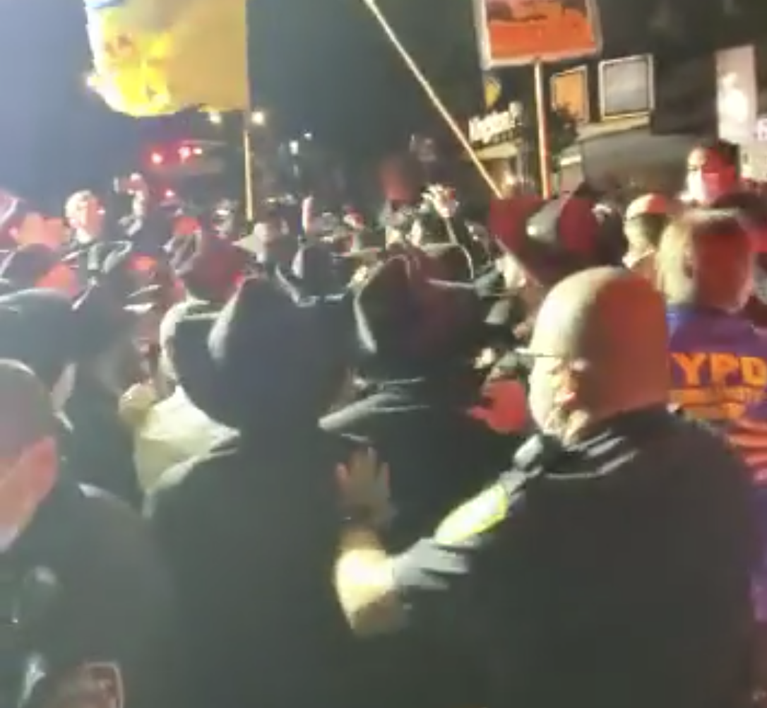 An NYPD officer attempting to disperse a large gathering in Crown Heights on Monday