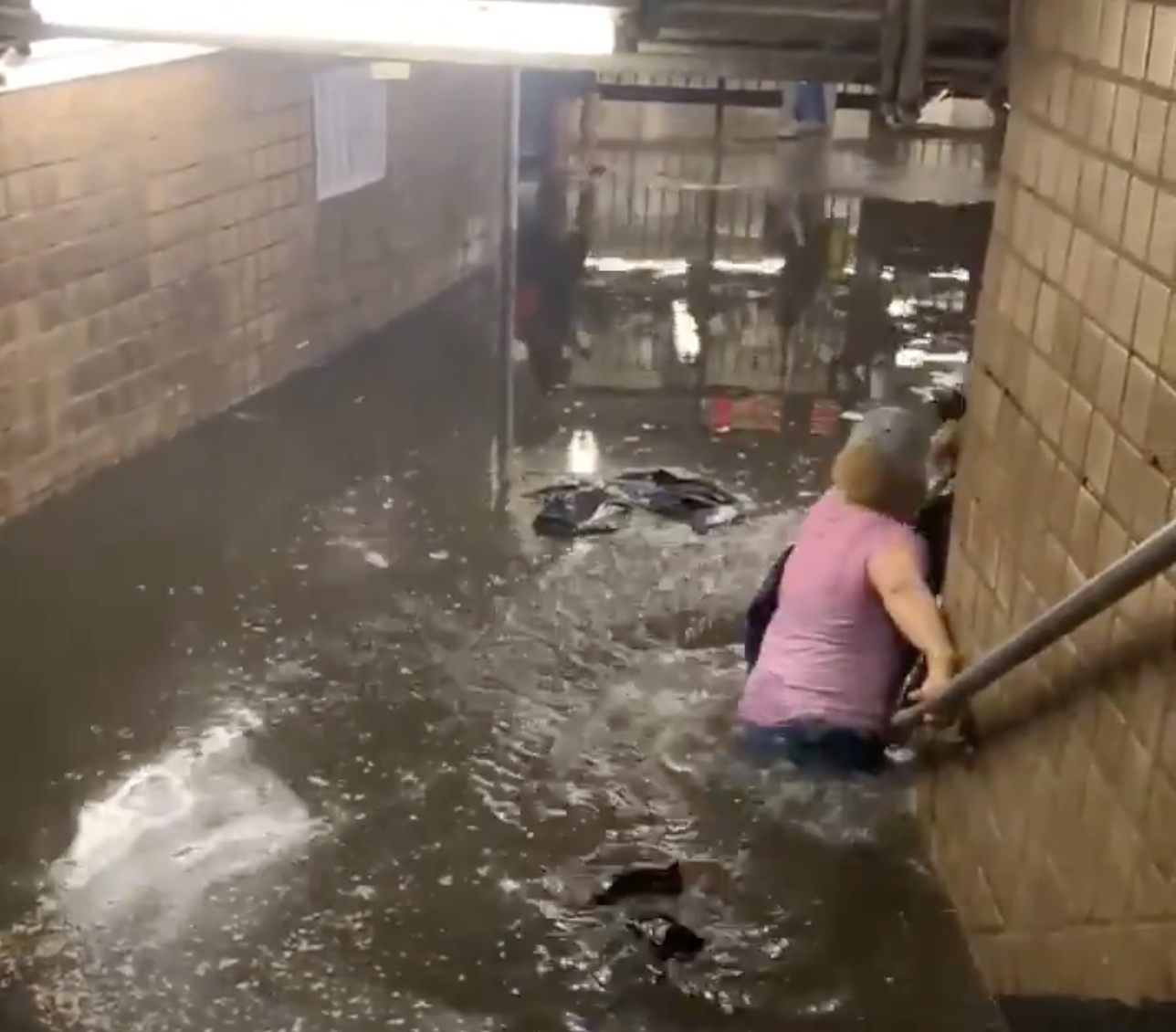 Subway Commuters Wade Through Waist-Deep Waters As Heavy Rainfall Triggers Flash Floods
