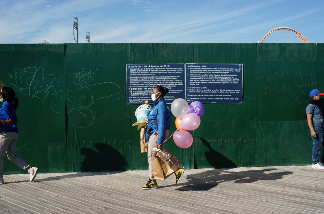A photo of a woman carrying balloons in Coney Island