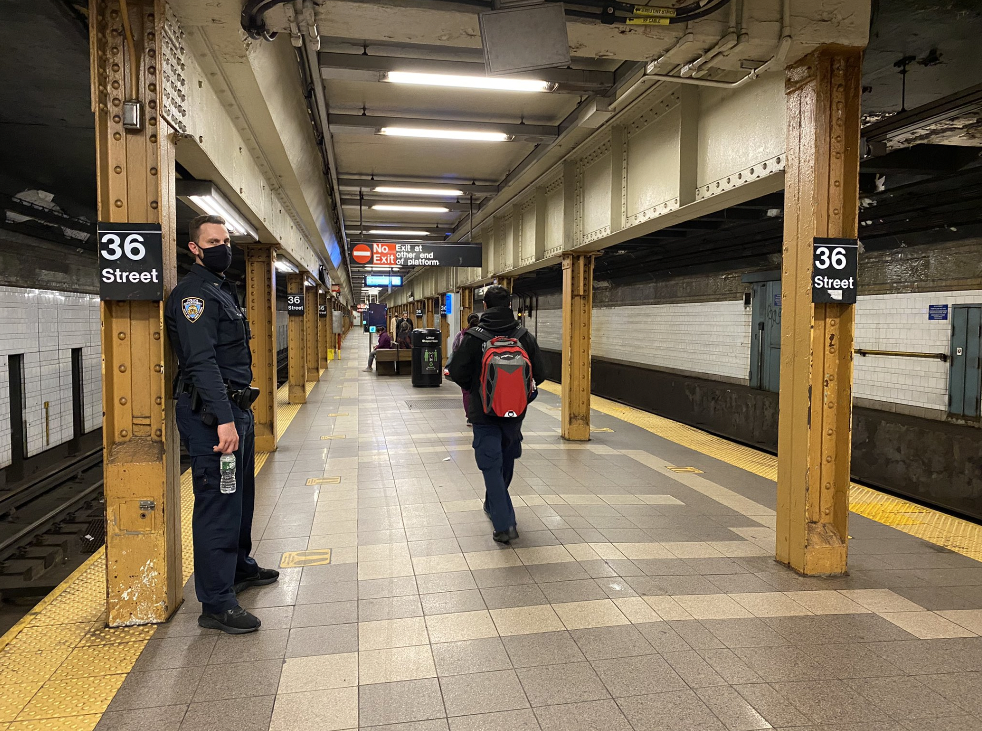 A police officer stands at the 36th Street station platform a day after a gunman opened fire on passengers