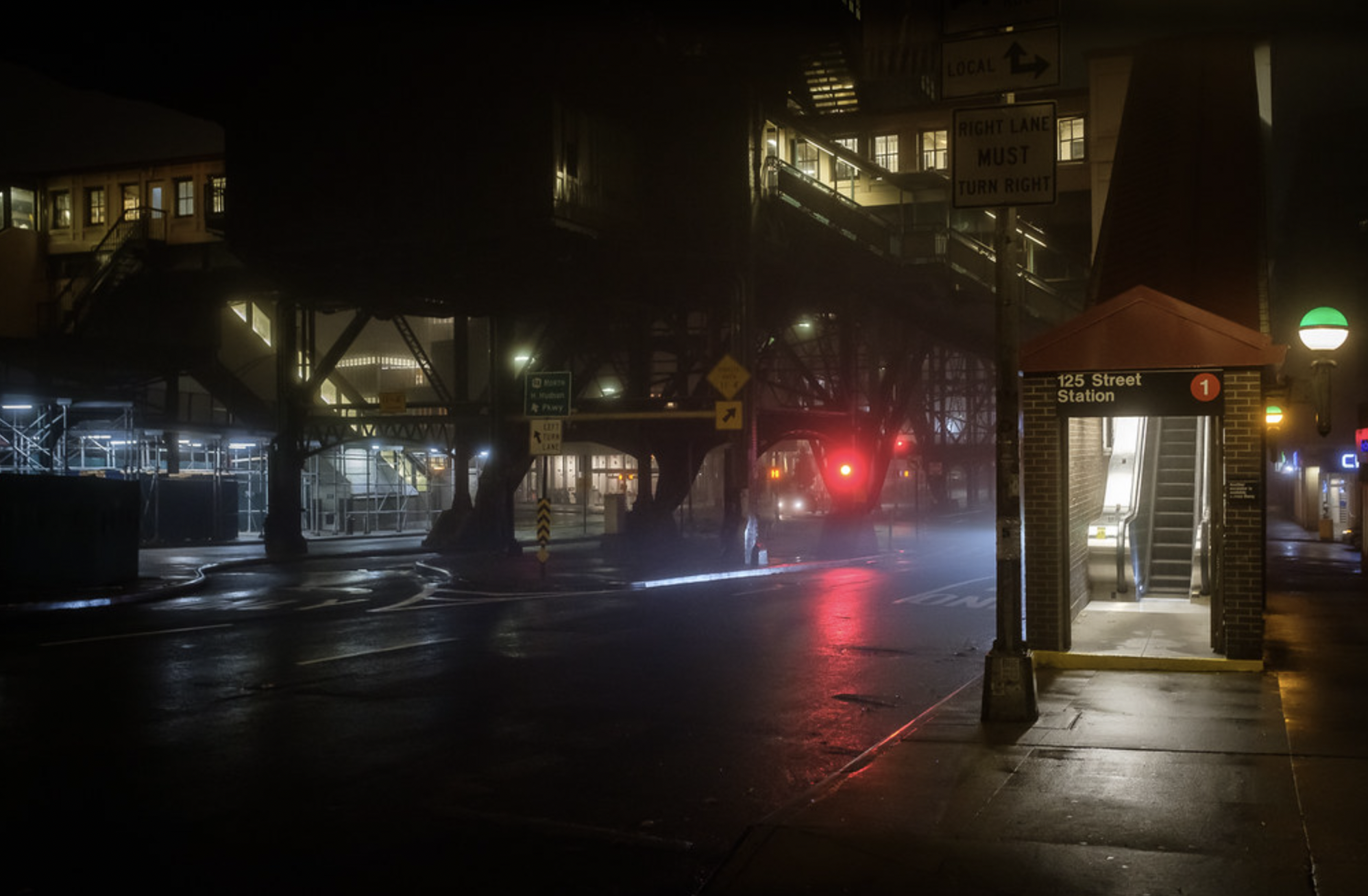 an outdoor subway track entrance on a foggy night