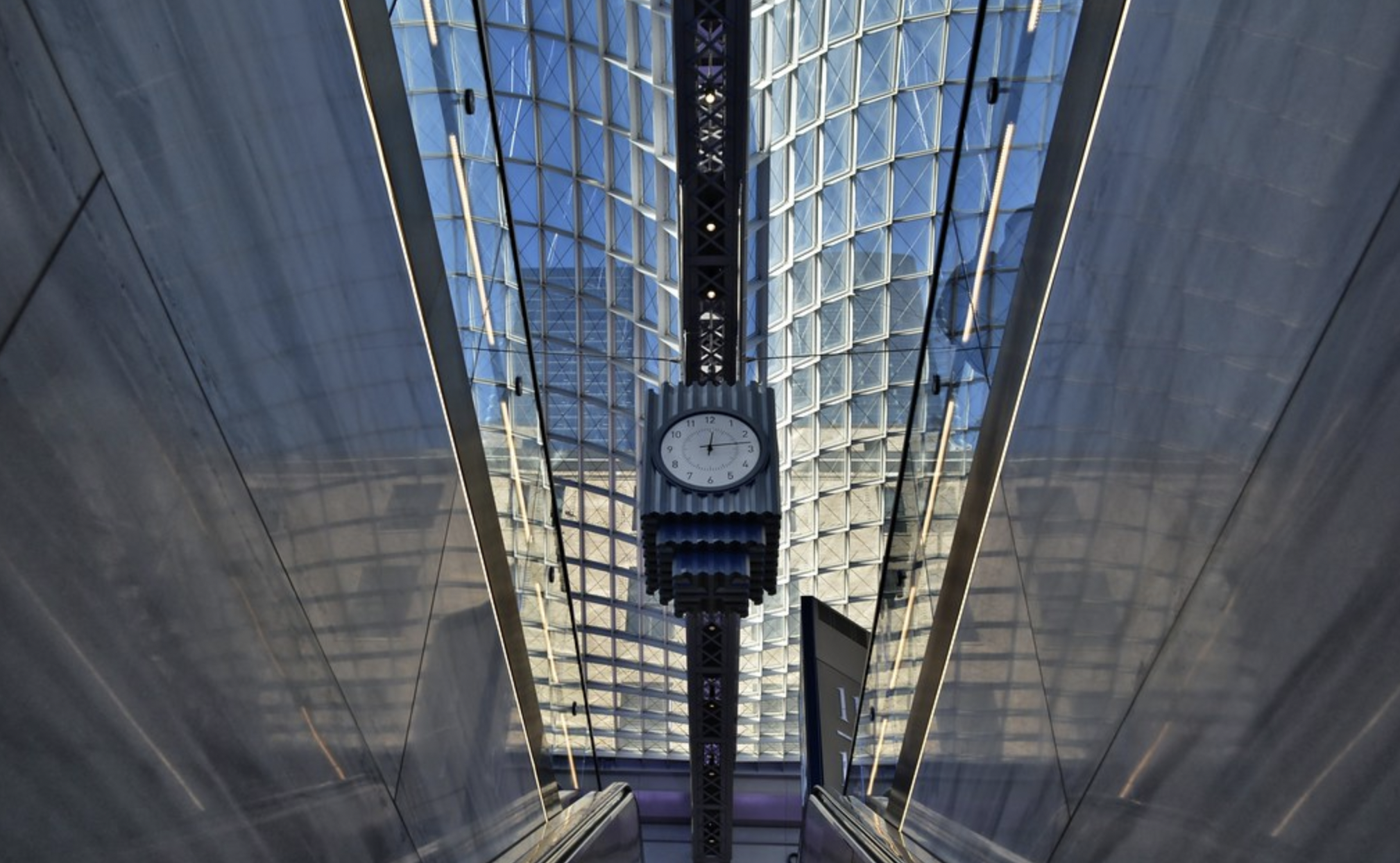 the clock at the top of a staircase at Moynihan Train Hall