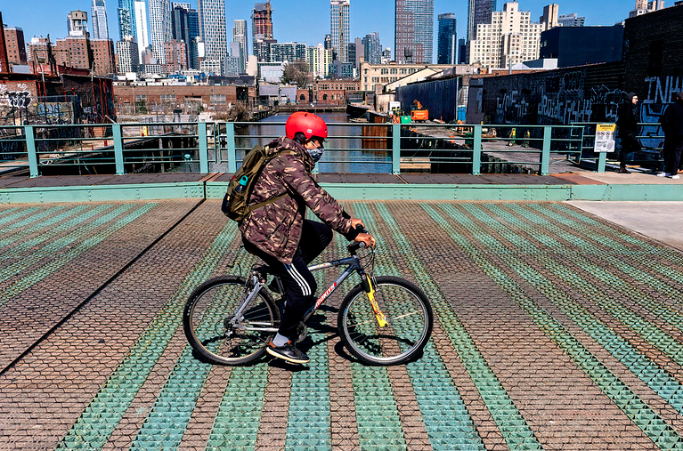 a cyclist crosses over the Gowanus Canal