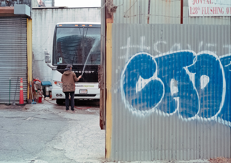 someone washes a bus in a garage in Brooklyn