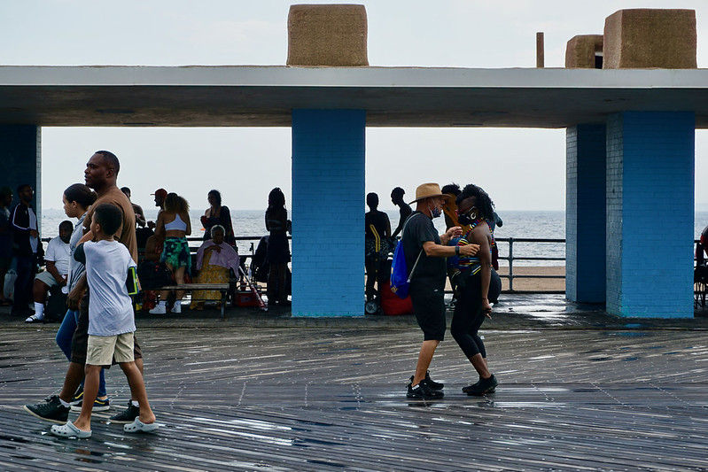 people dancing on the boardwalk in Coney Island