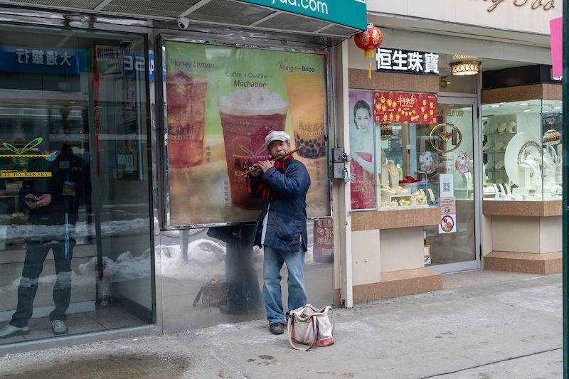 A Chinese street musician plays traditional flute on 1st day of Lunar New Year in Chinatown.