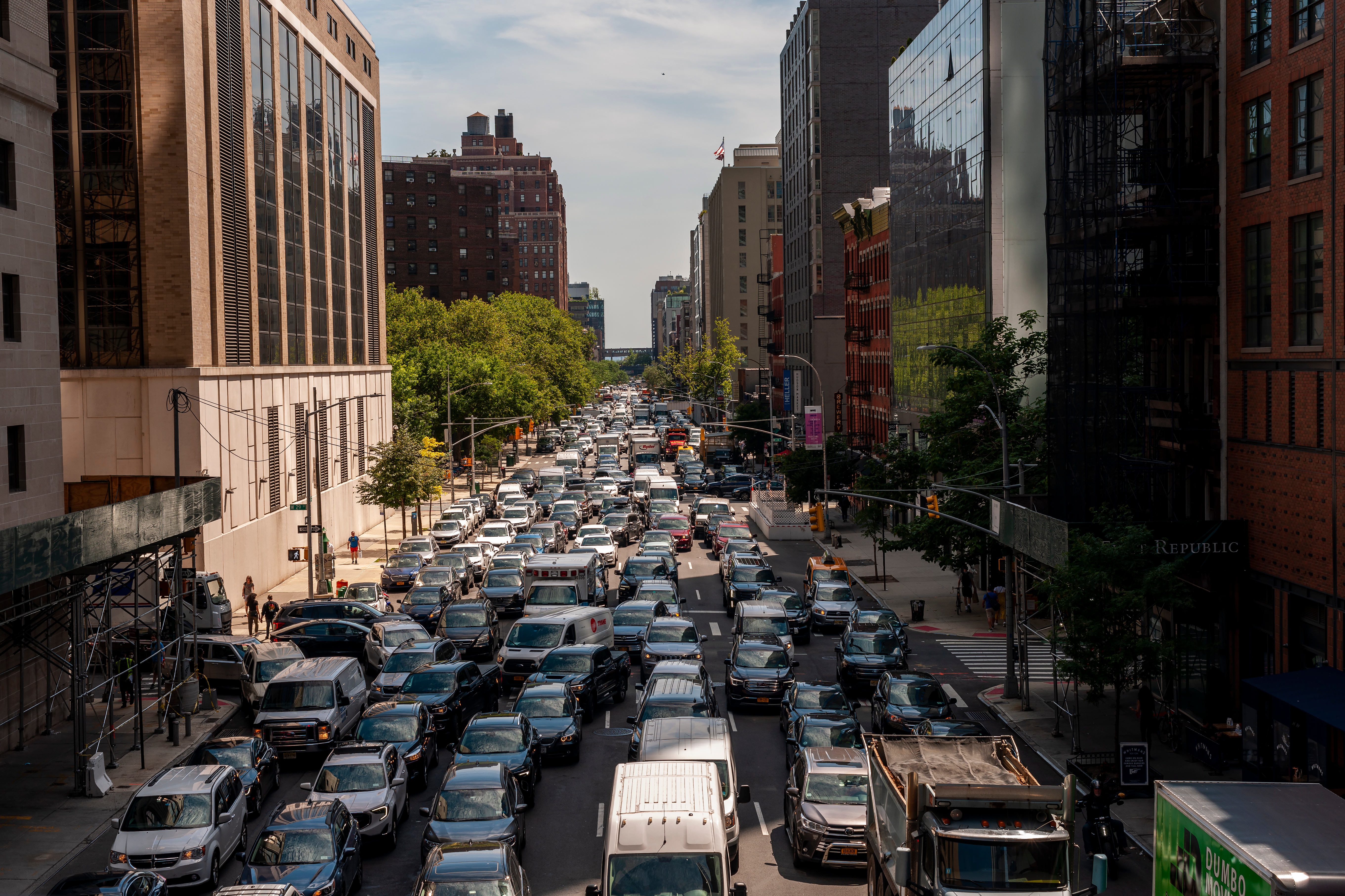 There are six lanes of packed vehicles on Tenth Avenue, looking south