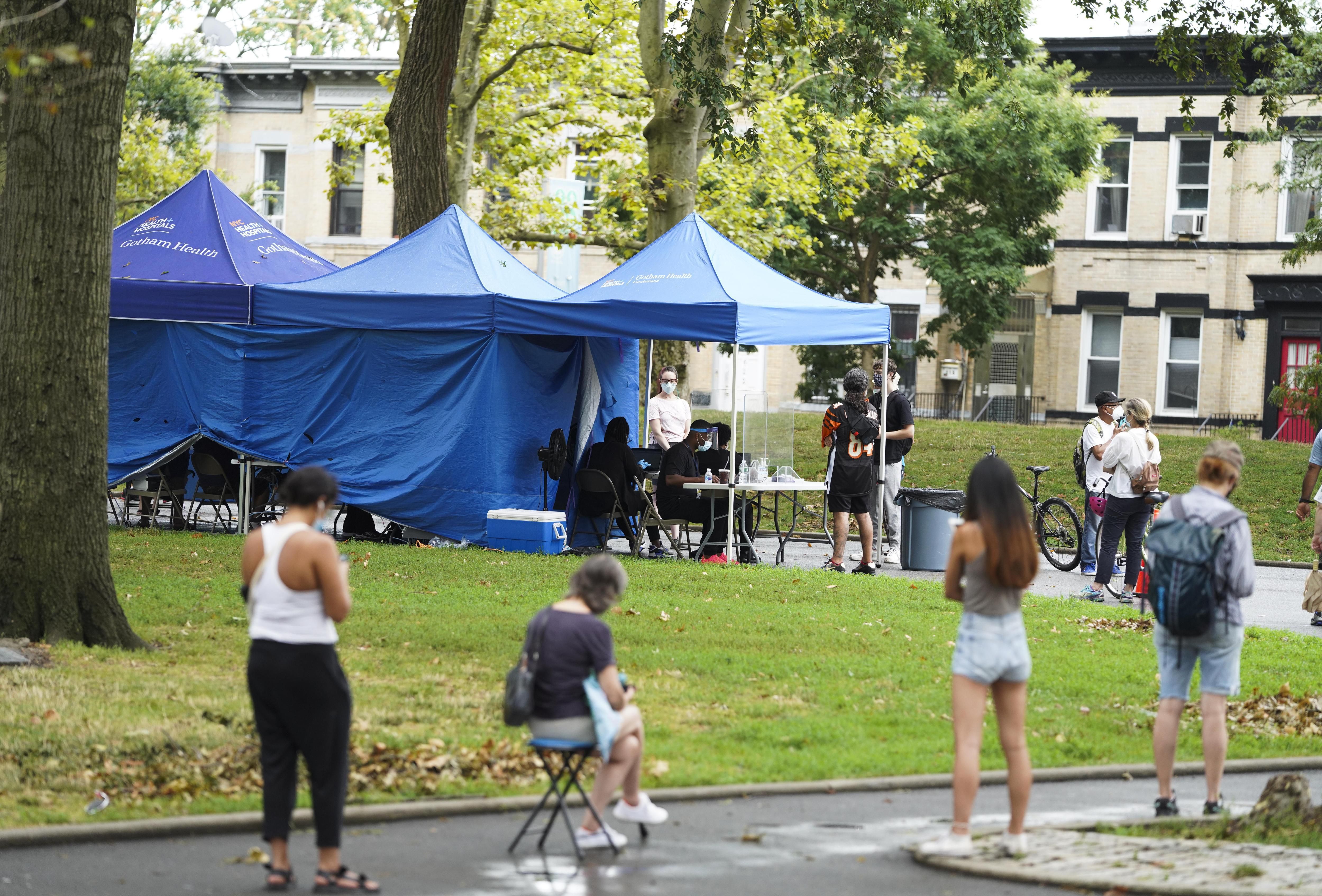 People wait on a line outside in the a city park to receive a COVID-19 test at a temporary test site in Sunset Park on Aug. 13th, 2020.
