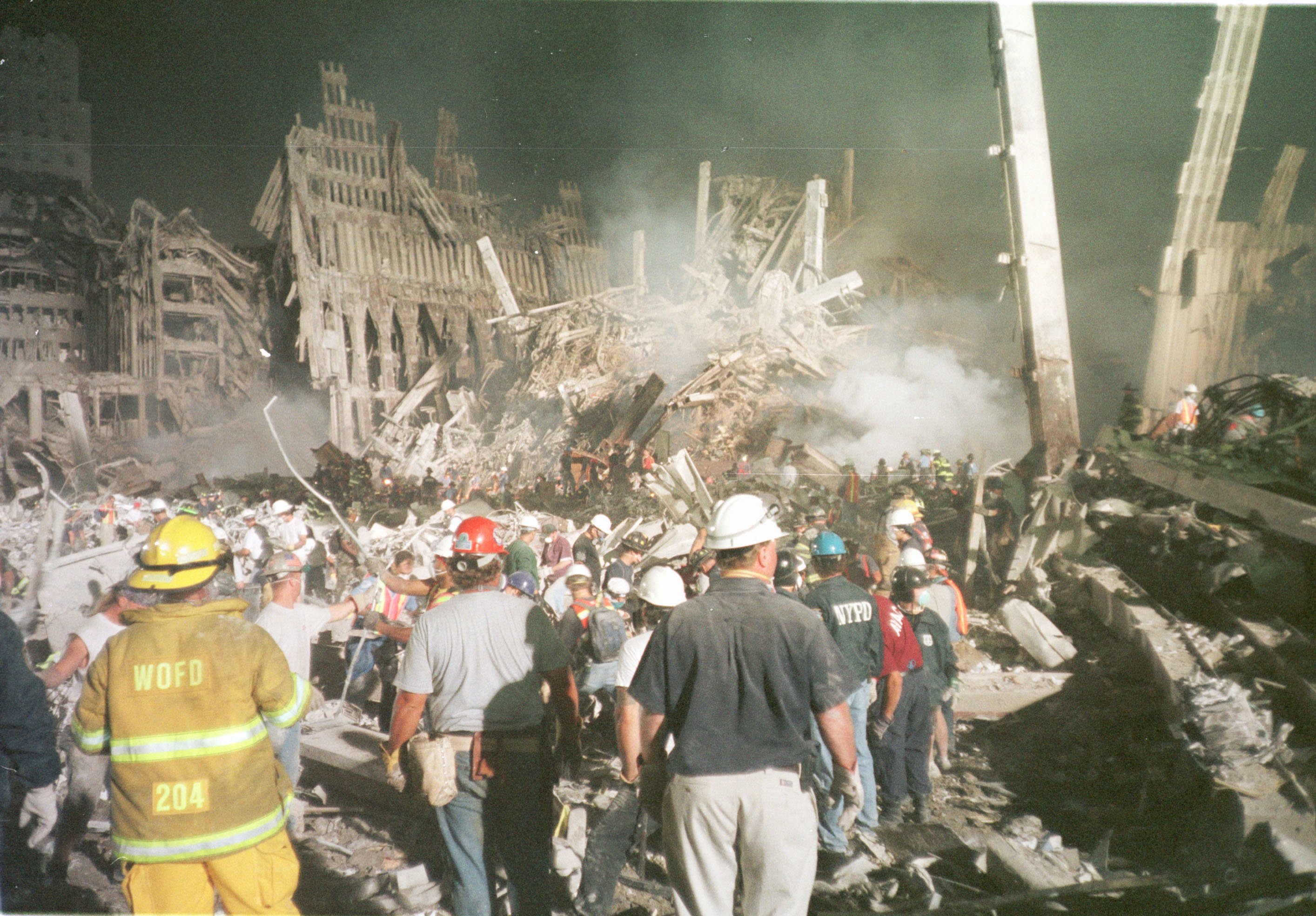 dozens of first responders stand in the dusty remains of the World Trade Center