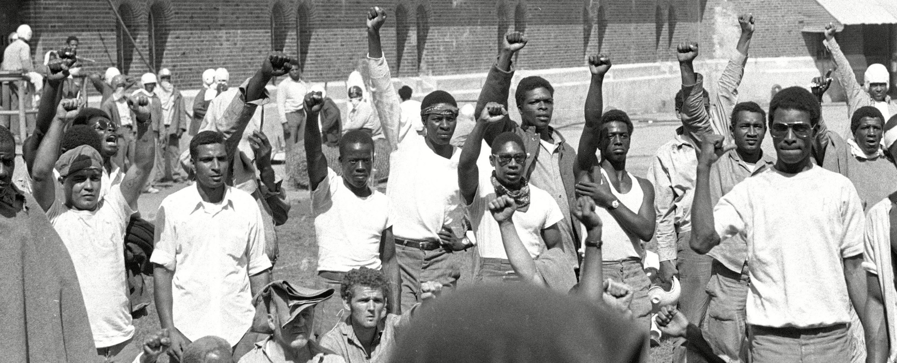 Prisoners raise their fists during the Attica uprising.