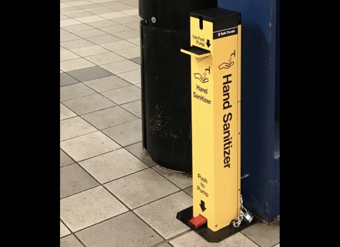 A hand sanitizer pump inside a subway station.