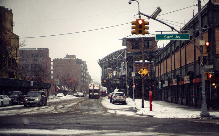 snow falls on Surf Ave in Coney Island