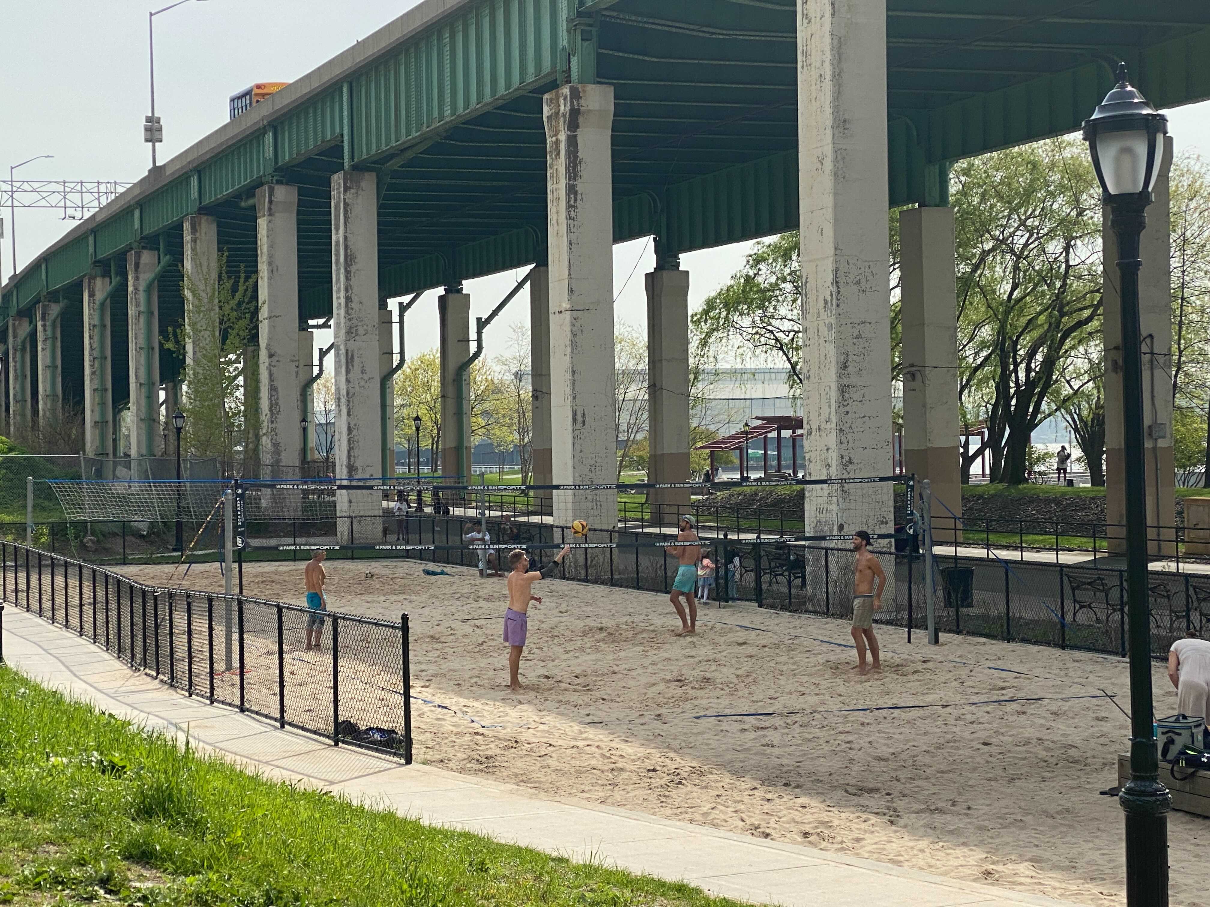 four guys playing beach volleyball on the Upper West Side