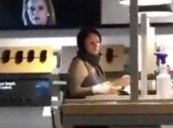A blurry screenshot from a cellphone video showing a woman who shouted a racial slur in a Manhattan Verizon store after refusing to wear a mask.